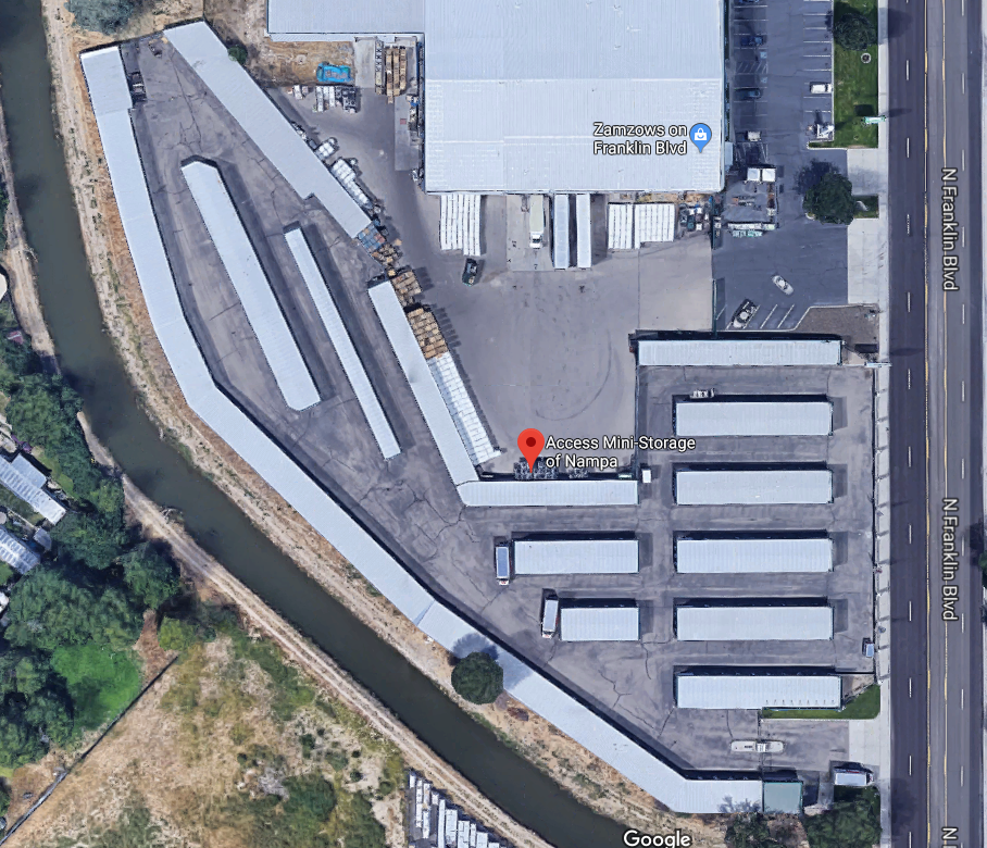 An aerial view of a parking lot with a building in the background