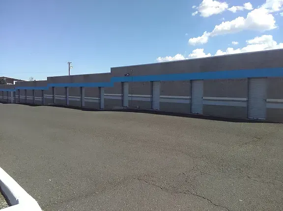 A row of garage doors are lined up in a parking lot.