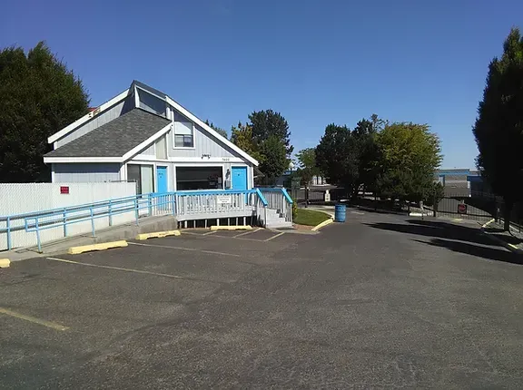 A white and blue building with a ramp in front of it