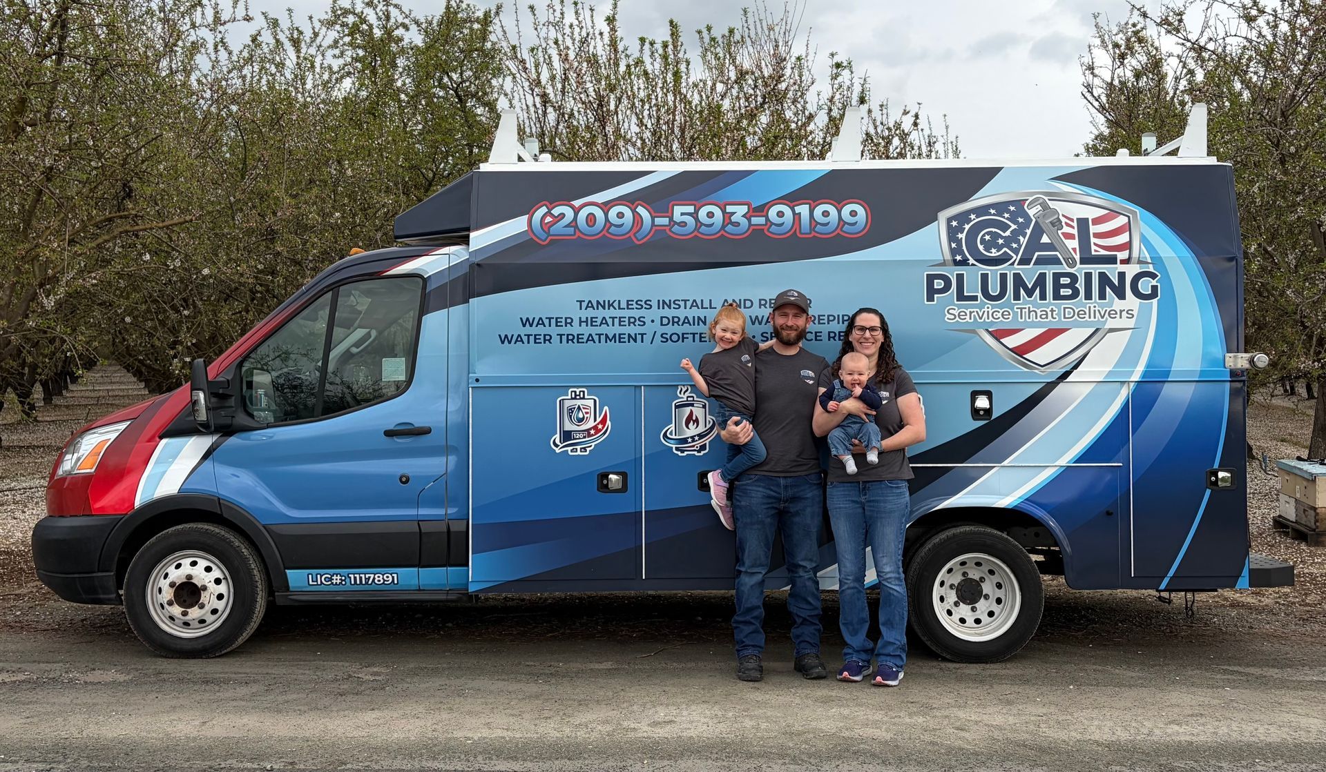 Tankless water heater installed in a metal enclosure with plumbing and a water filter.