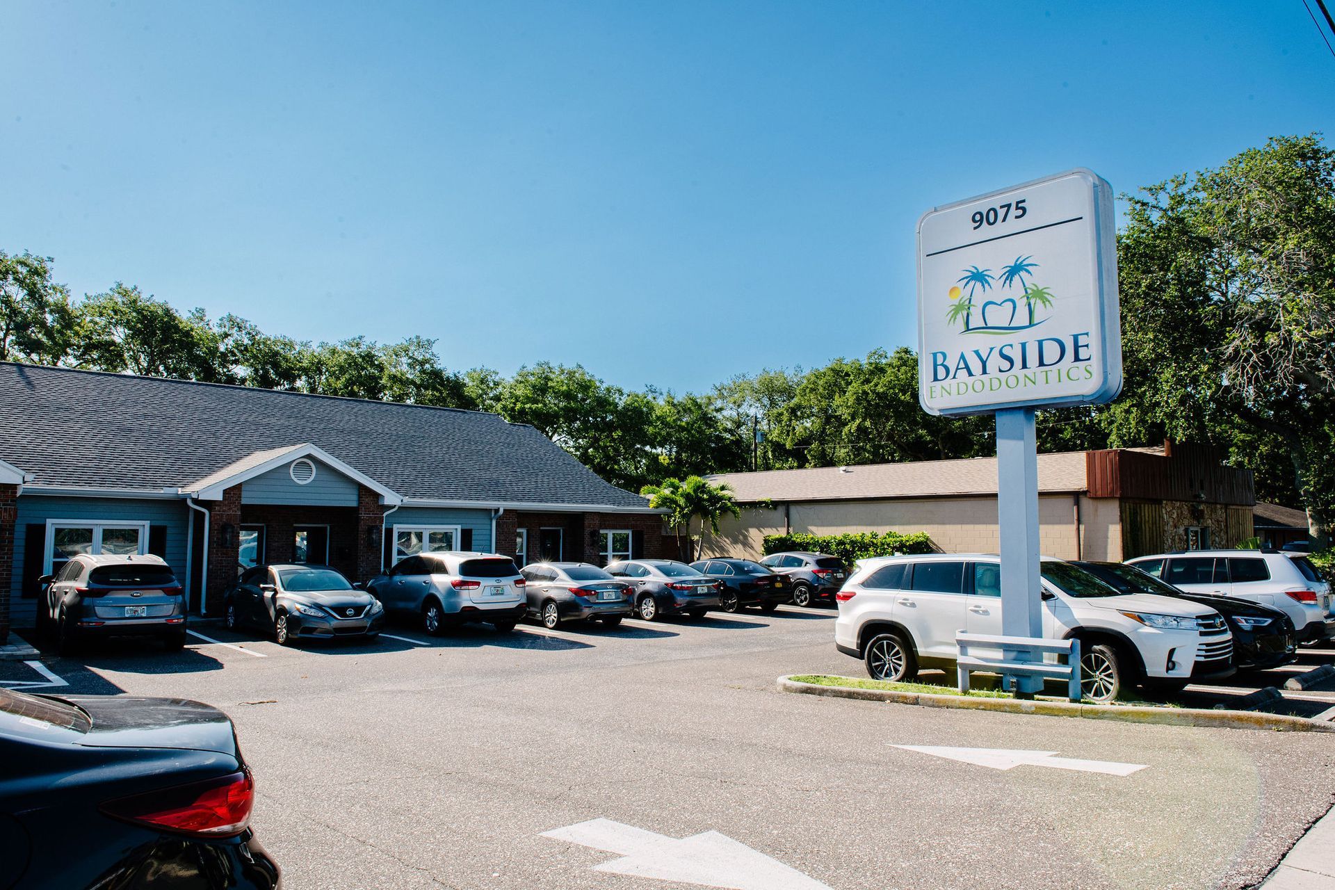 A lot of cars are parked in front of a building with a sign that says bayside.