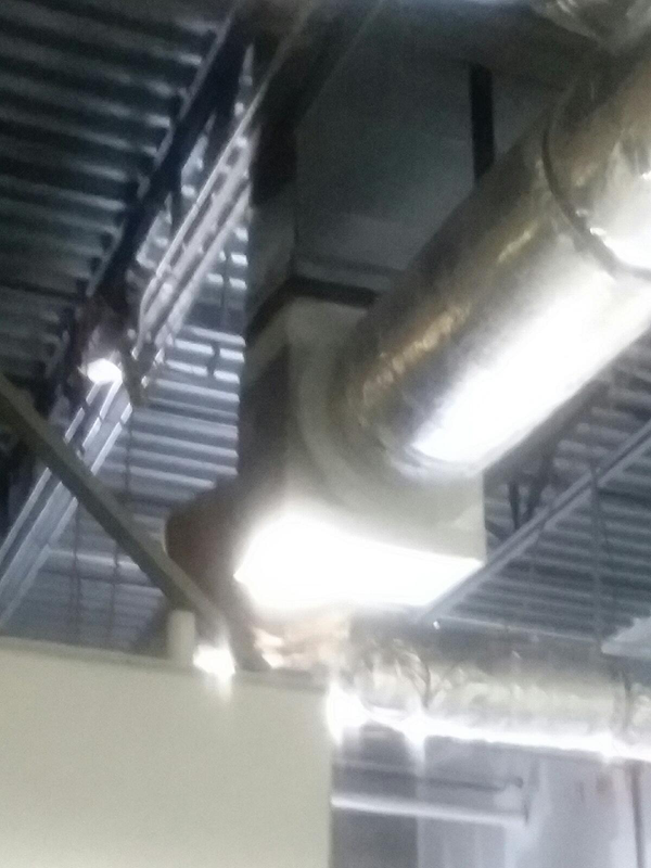 HVAC ductwork, silver, against a white ceiling, angled view.