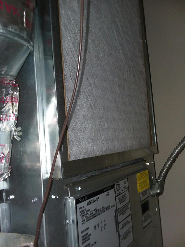 HVAC air filter inside a metal cabinet, with wiring and a label visible.