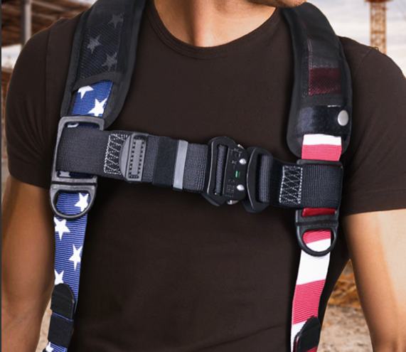 Close-up of a black harness strap with star and red-white-blue patterns on a person’s torso