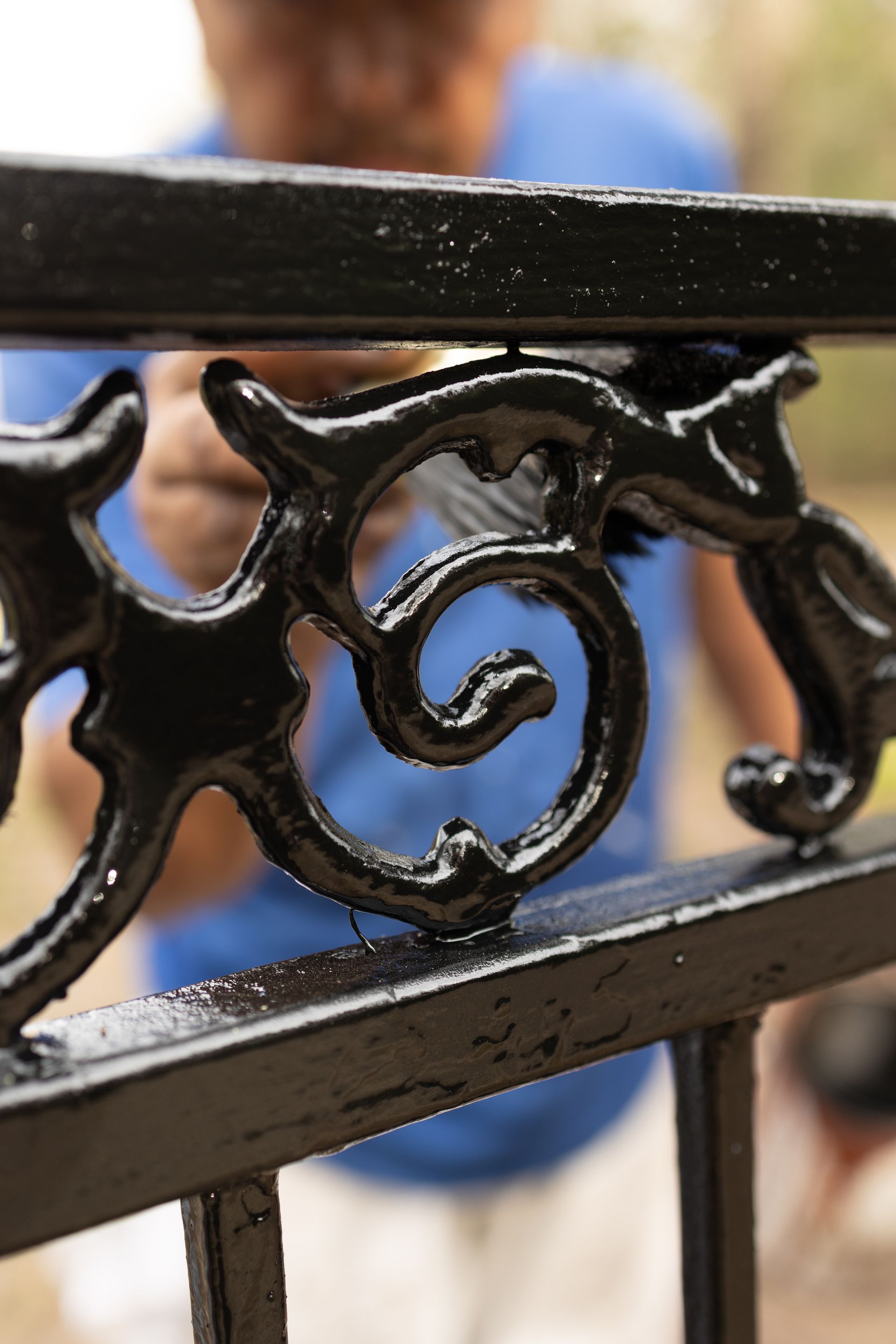 A close up of a black fence with a person in the background