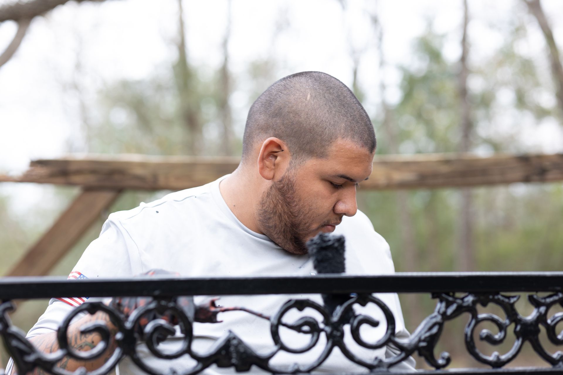 A man is working on a wrought iron fence.