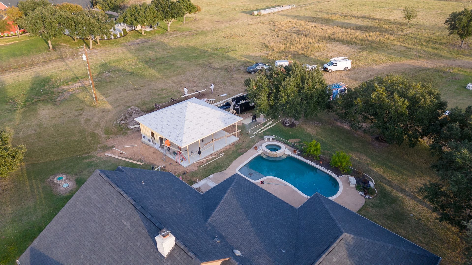 An aerial view of a house with a swimming pool in the backyard.