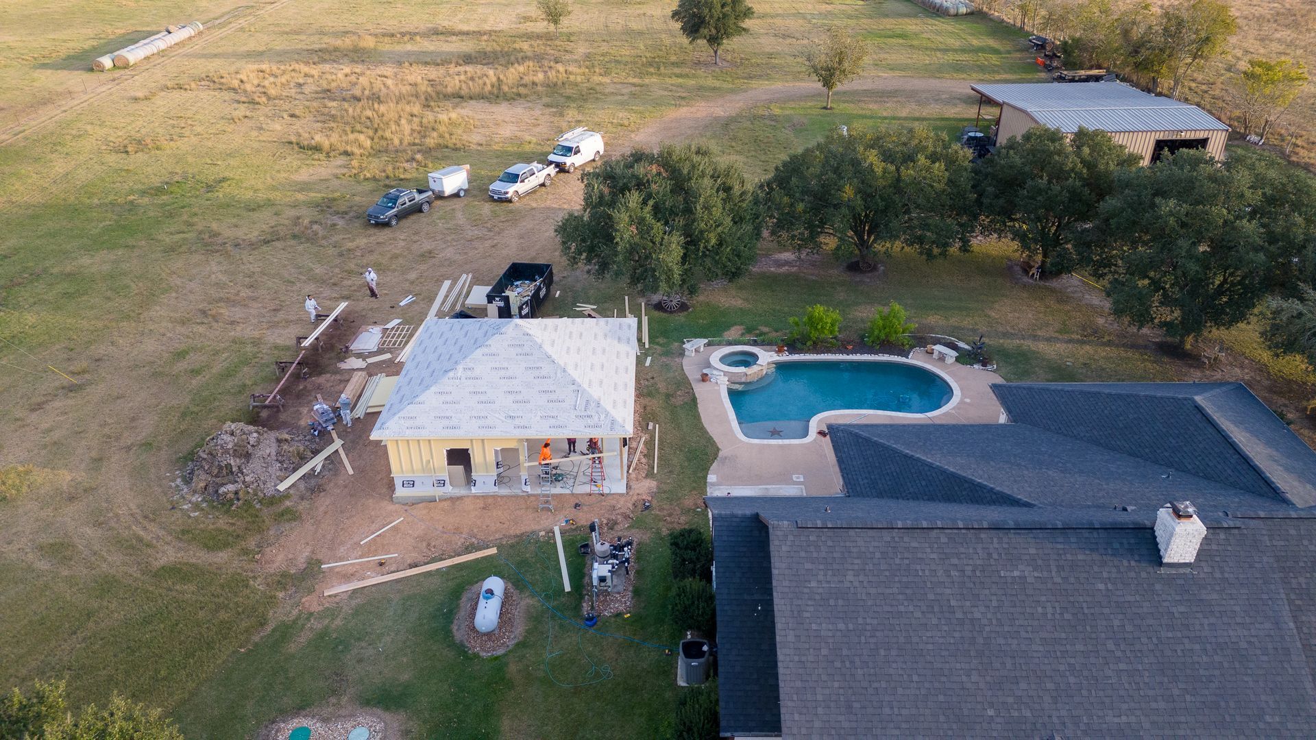 An aerial view of a house with a pool in the backyard.