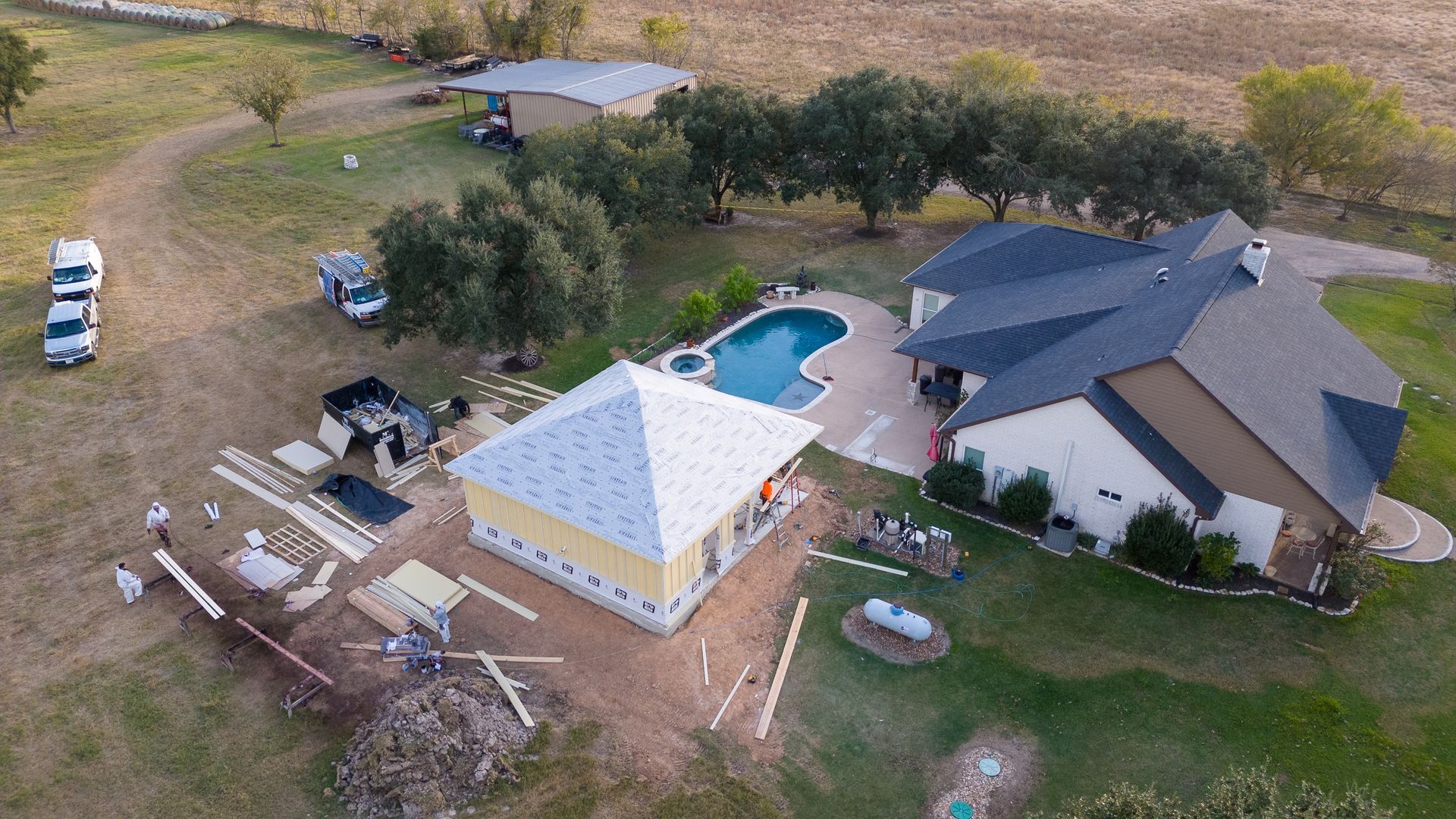 An aerial view of a house with a pool in the backyard.
