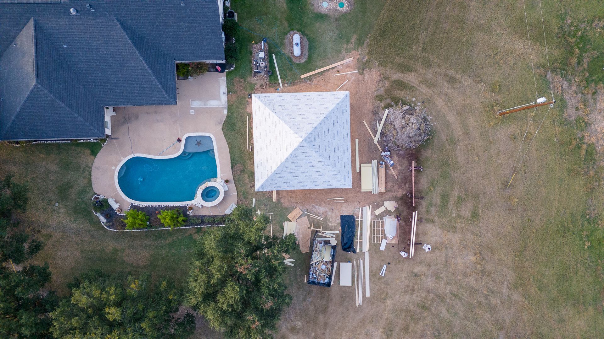 An aerial view of a house with a pool and a tent in the backyard.