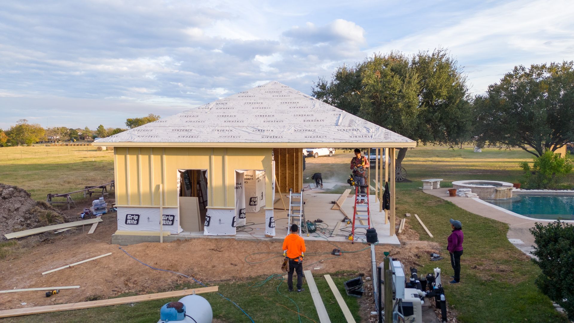 A group of people are working on a house under construction.
