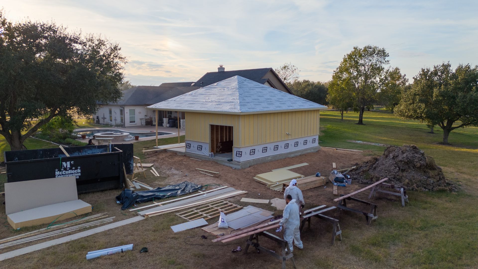 An aerial view of a house under construction in a field.