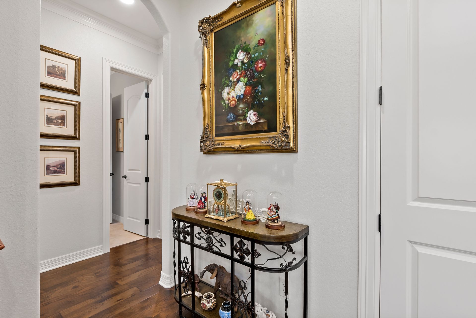 A hallway with a table and a painting on the wall.
