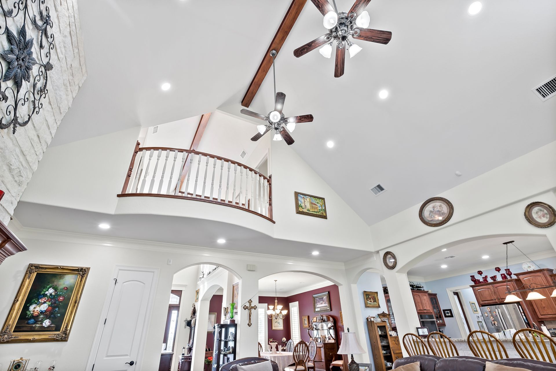 A living room with a ceiling fan and a balcony.