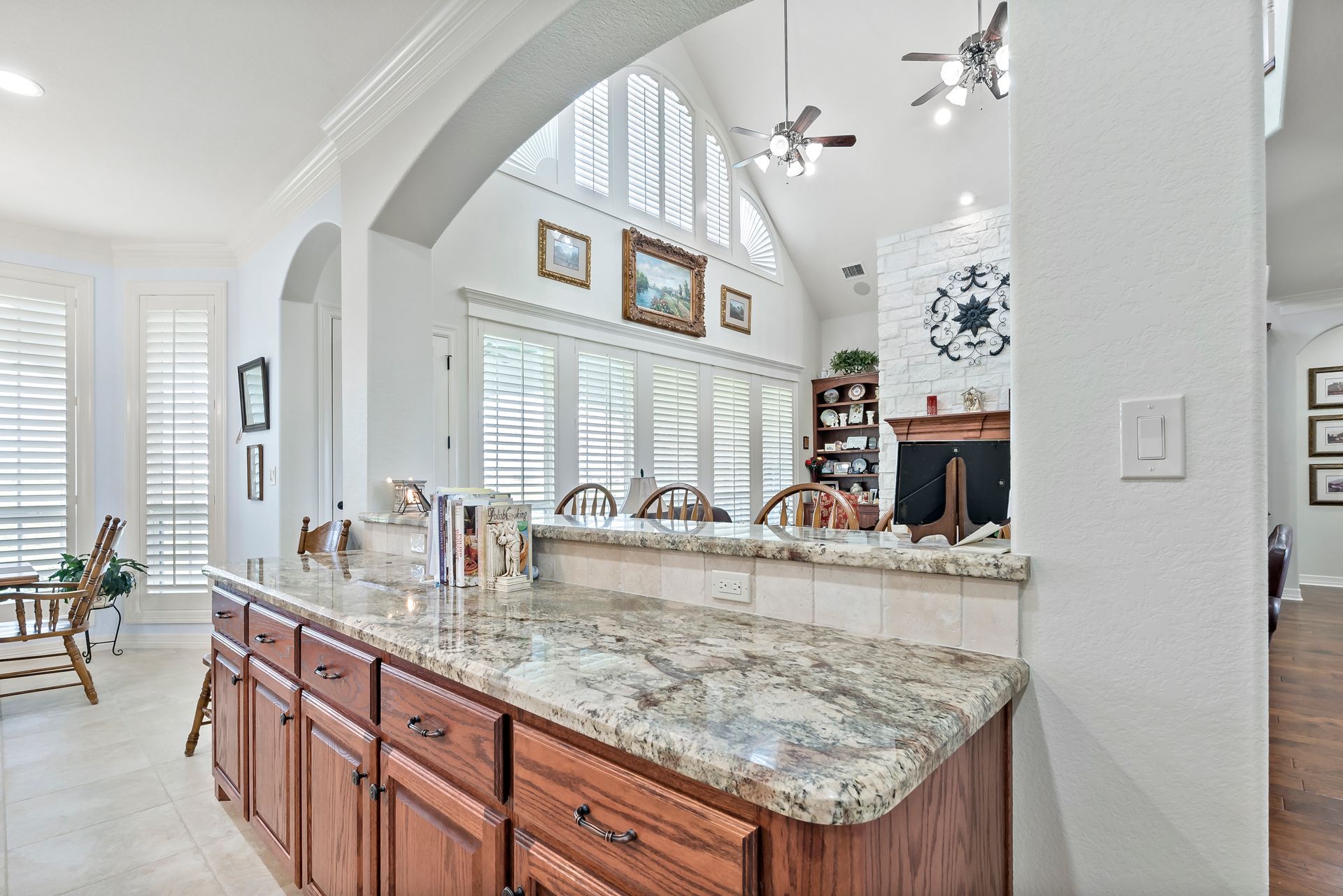A kitchen with granite counter tops and wooden cabinets.