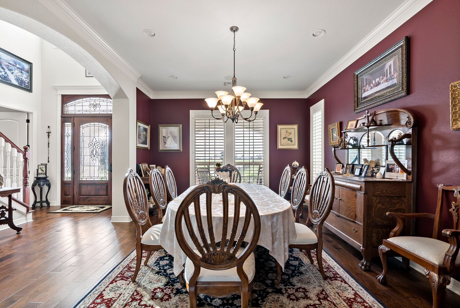A dining room with a table and chairs and a chandelier.