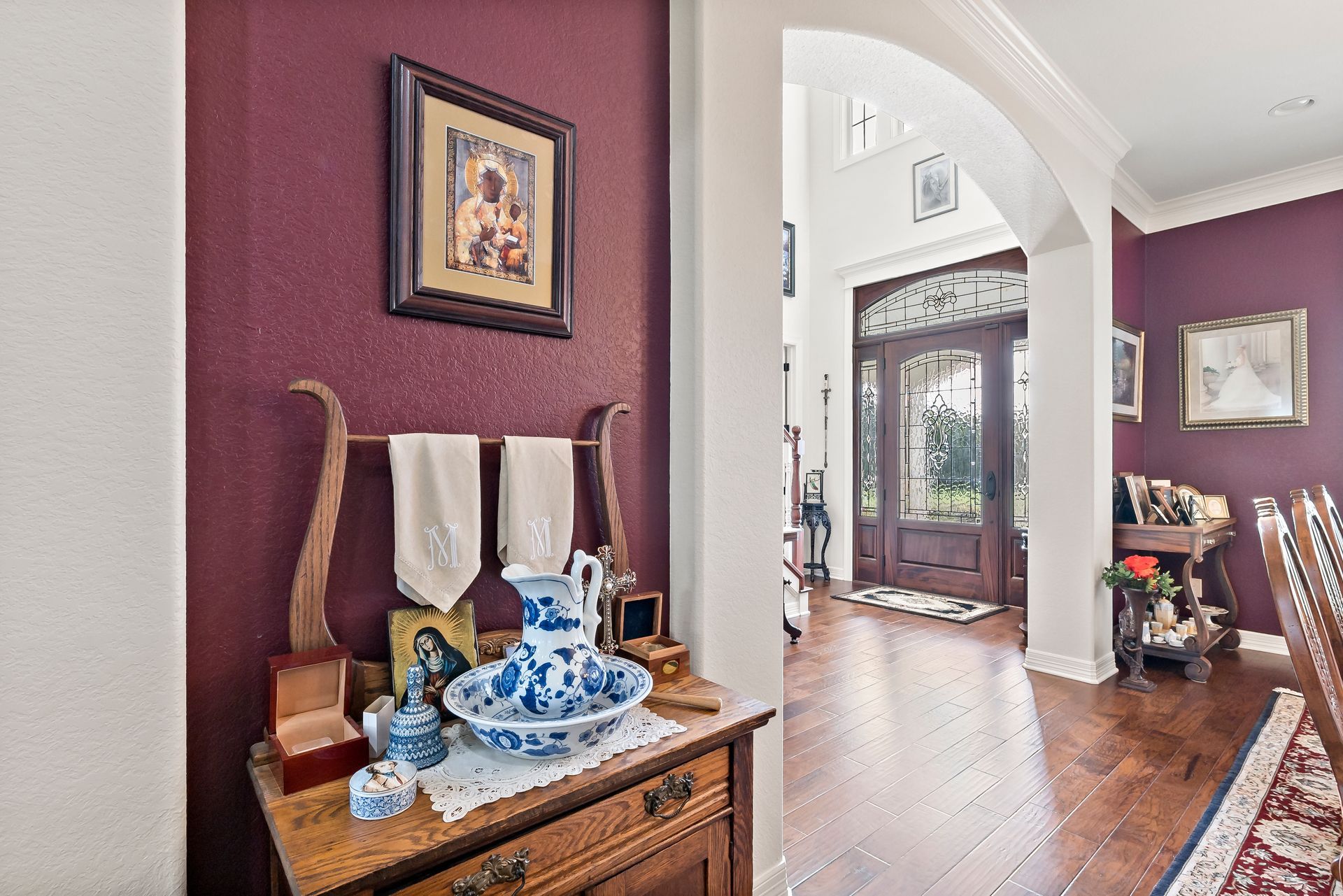 A living room with purple walls and a dresser with a vase on it.
