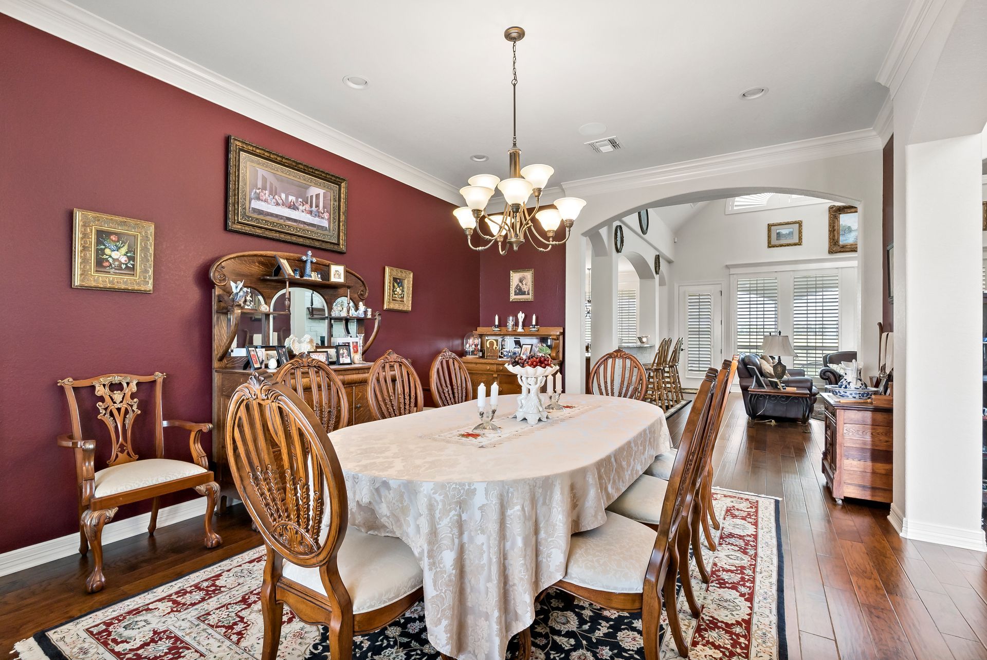 A dining room with a round table and chairs and a chandelier.