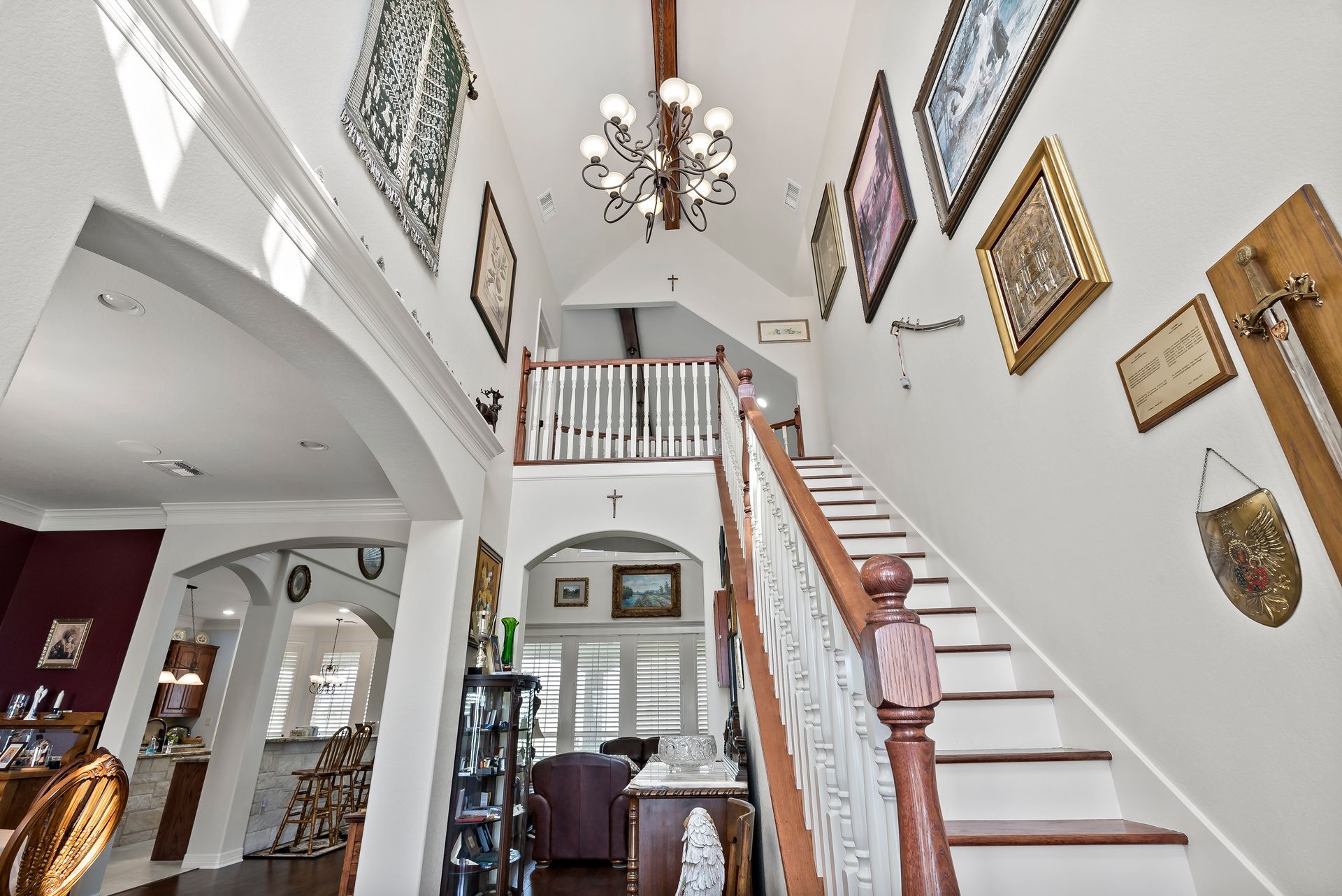 A staircase in a house with a chandelier hanging from the ceiling