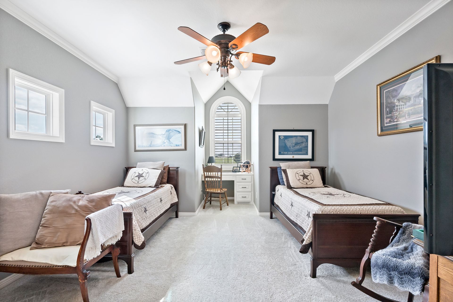 A bedroom with two beds and a ceiling fan.
