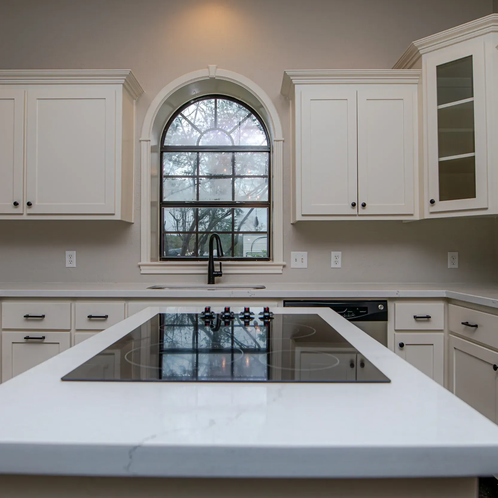 A kitchen with white cabinets and a stove top oven