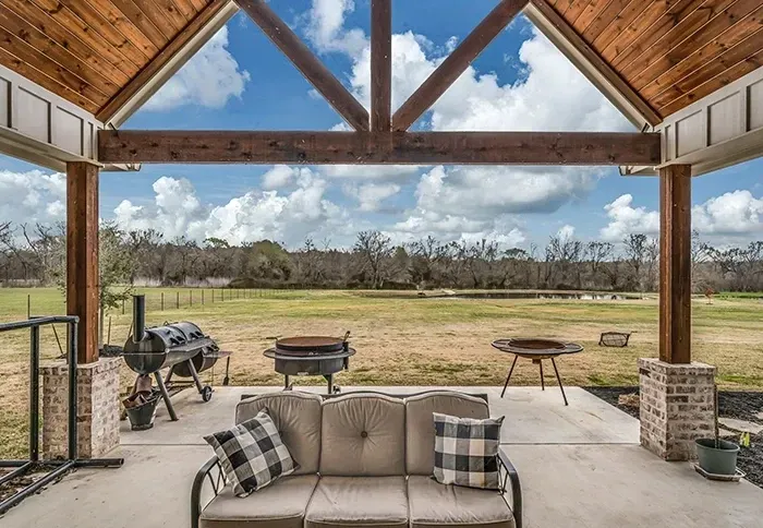 A living room with a couch and a view of a field.