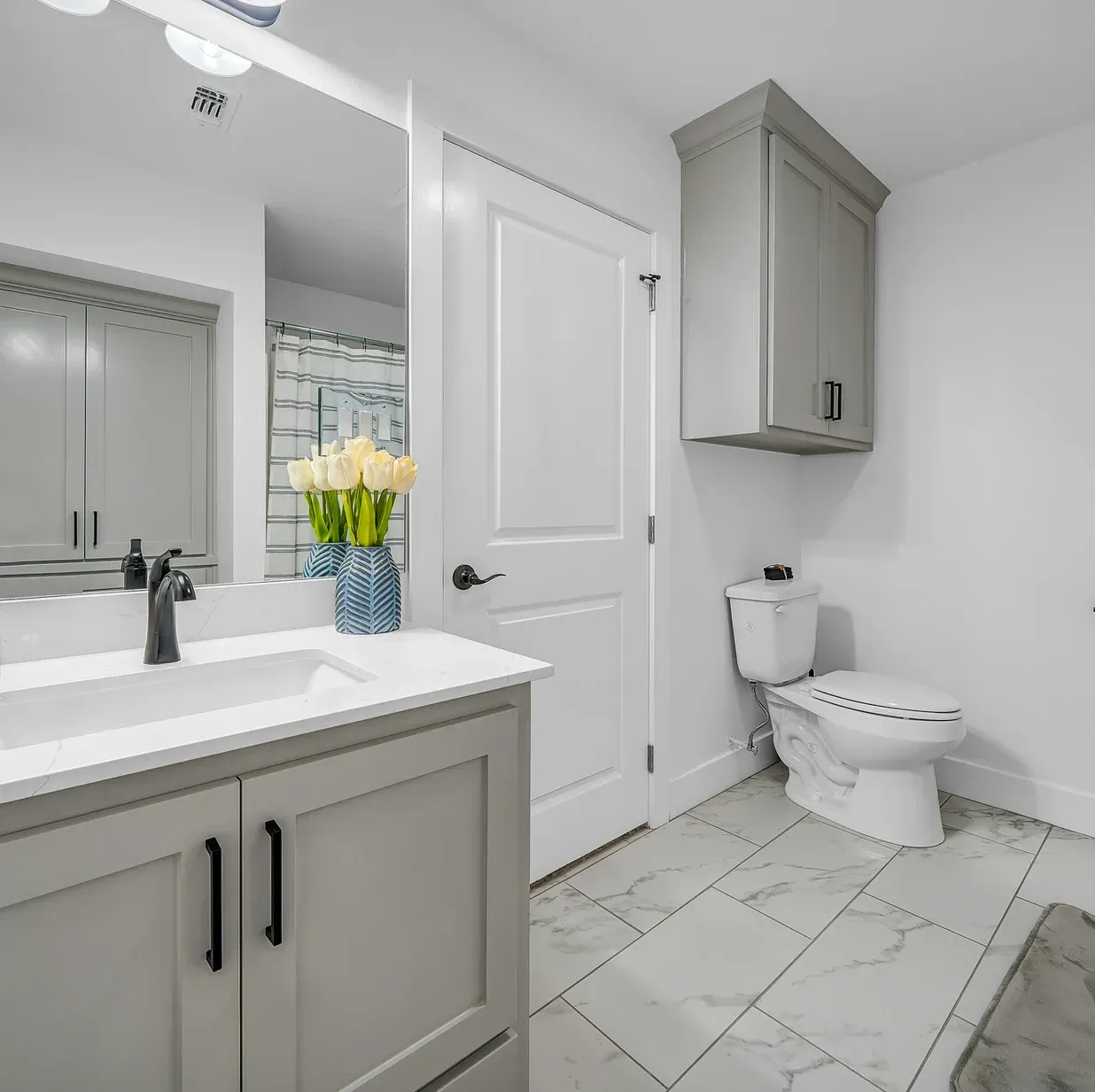 A bathroom with a sink , toilet and mirror.