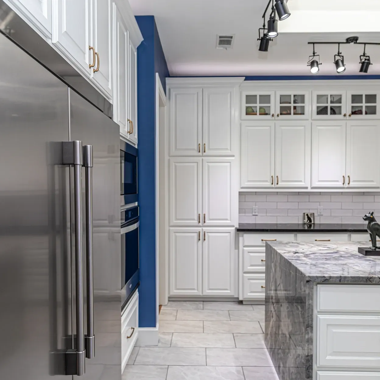 A kitchen with white cabinets and stainless steel appliances.