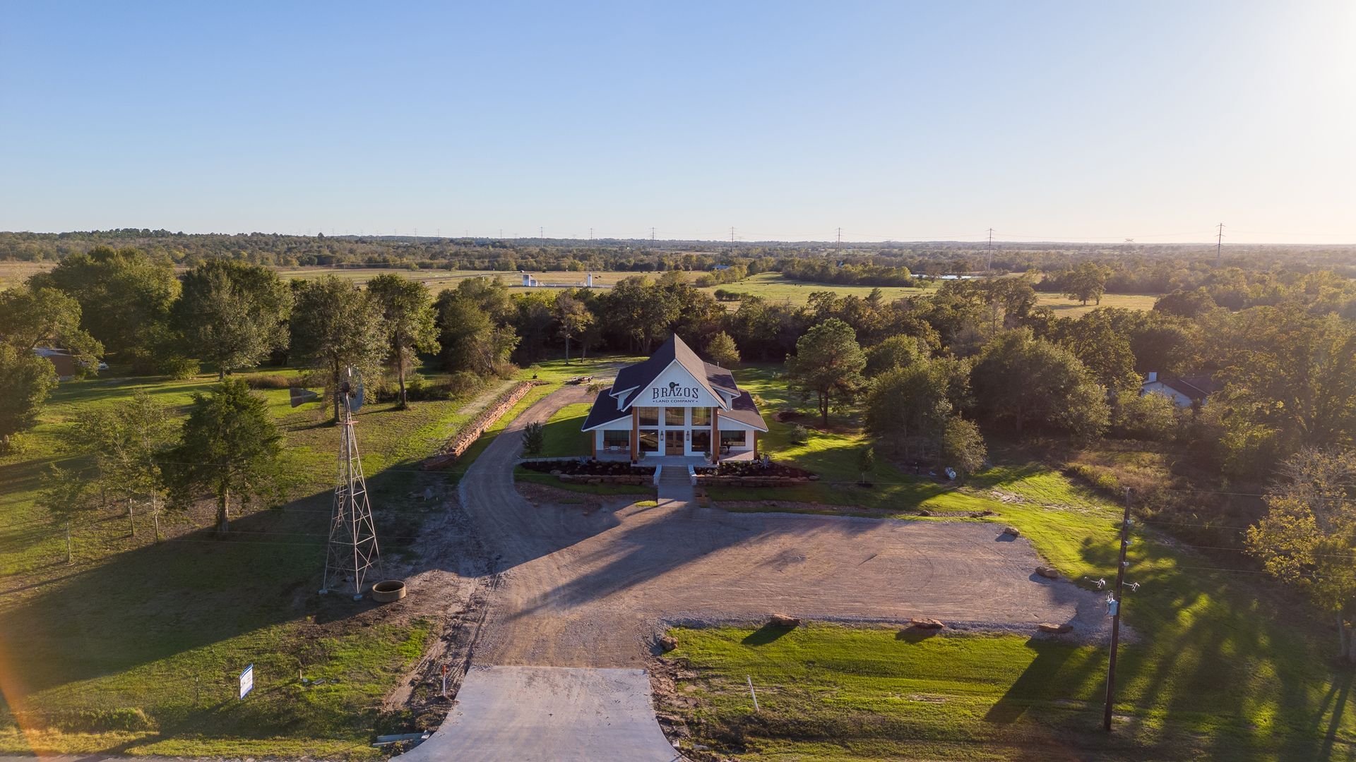 An aerial view of a large white house surrounded by trees and grass.