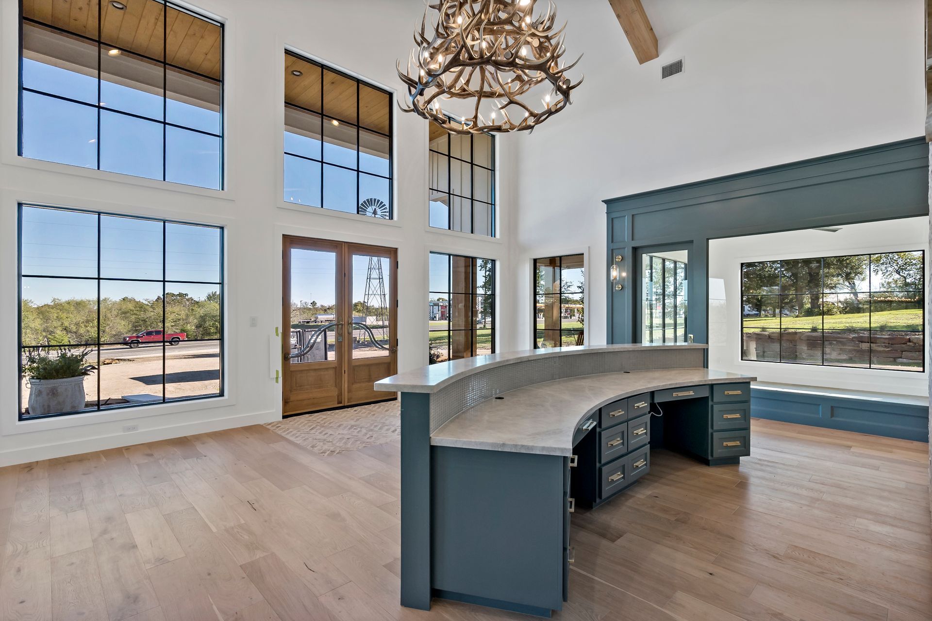 A large room with a curved desk and a chandelier hanging from the ceiling.