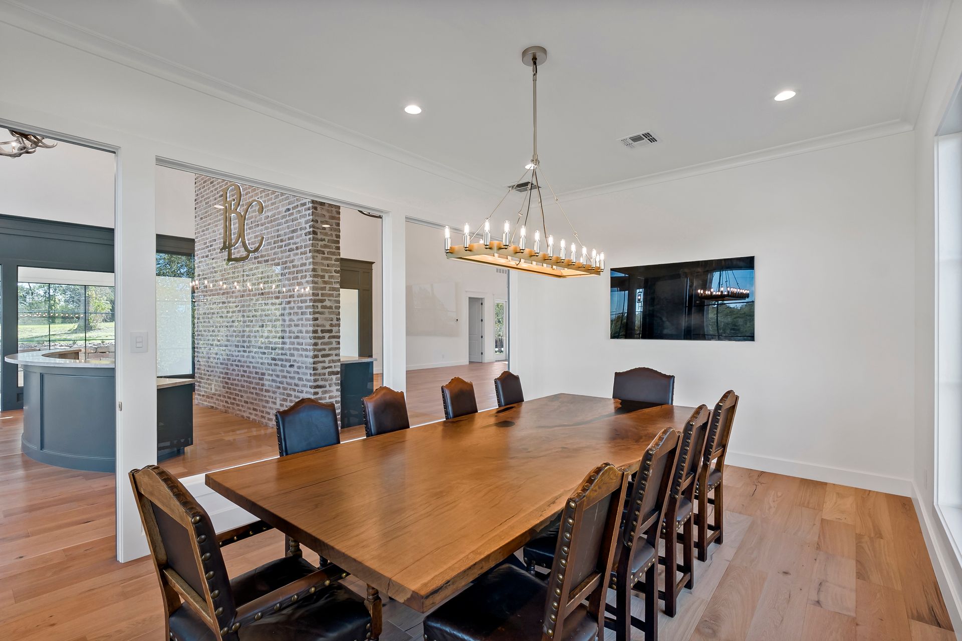 A dining room with a long wooden table and chairs.