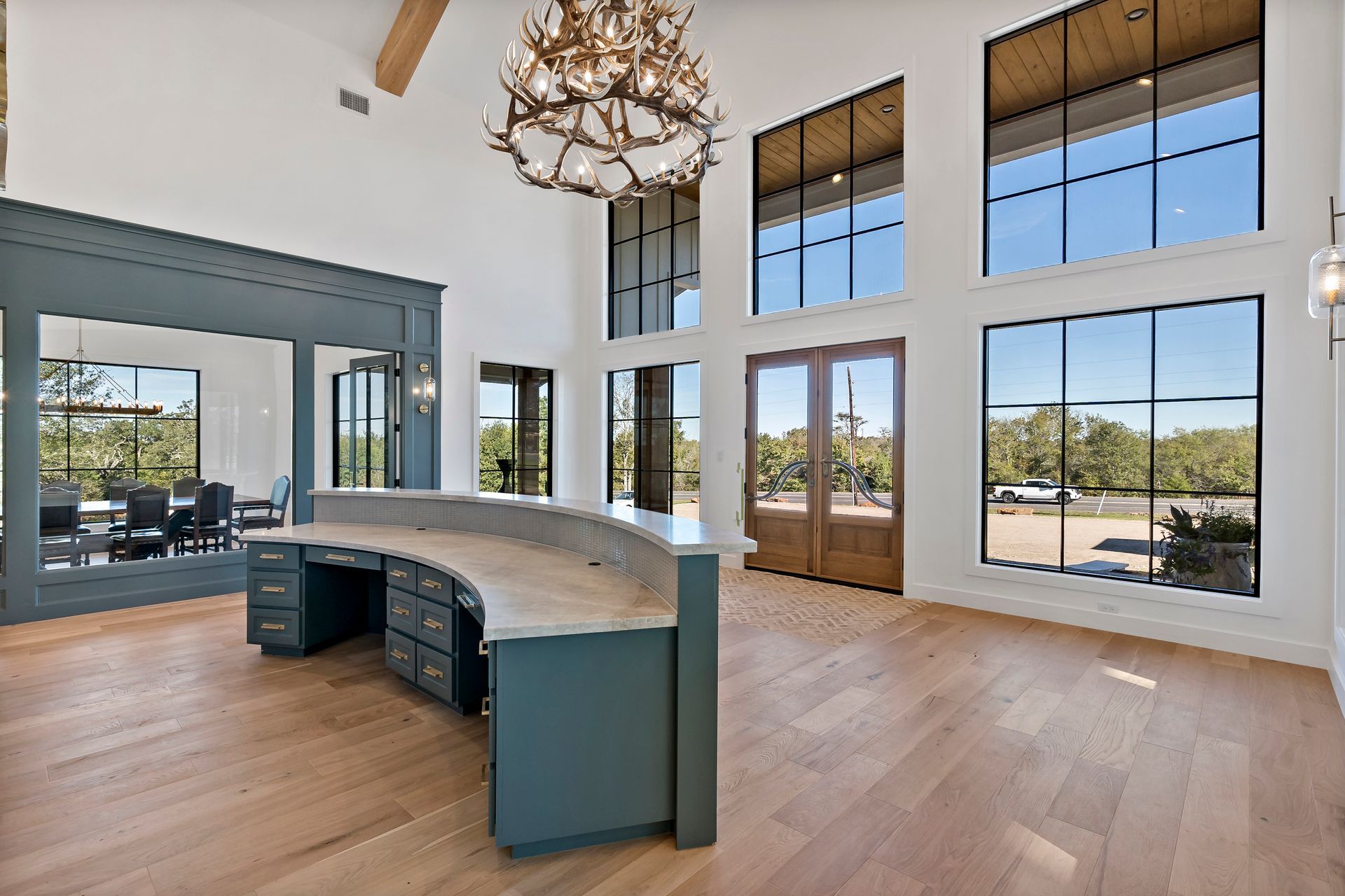 A large room with a desk and a chandelier.