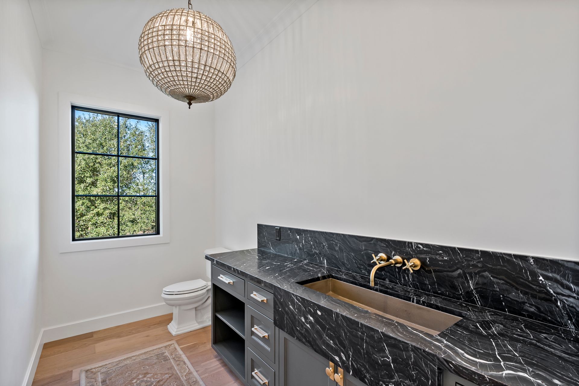 A bathroom with a sink , toilet and window.