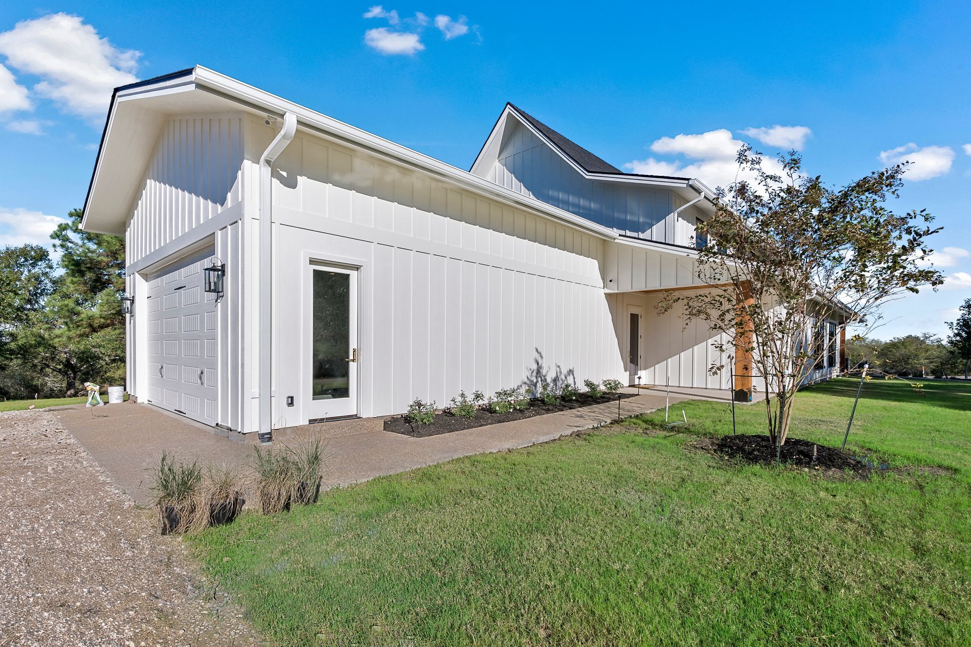 A white house is sitting on top of a lush green field.