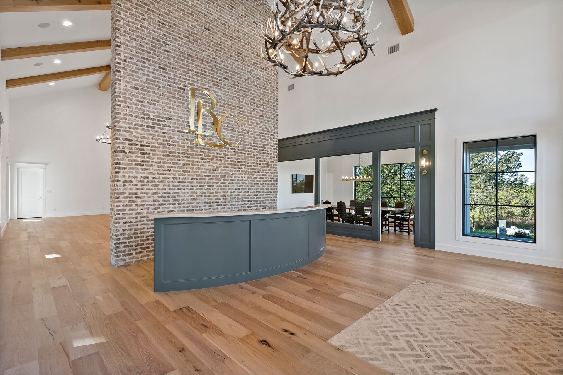 A large room with hardwood floors and a brick wall.