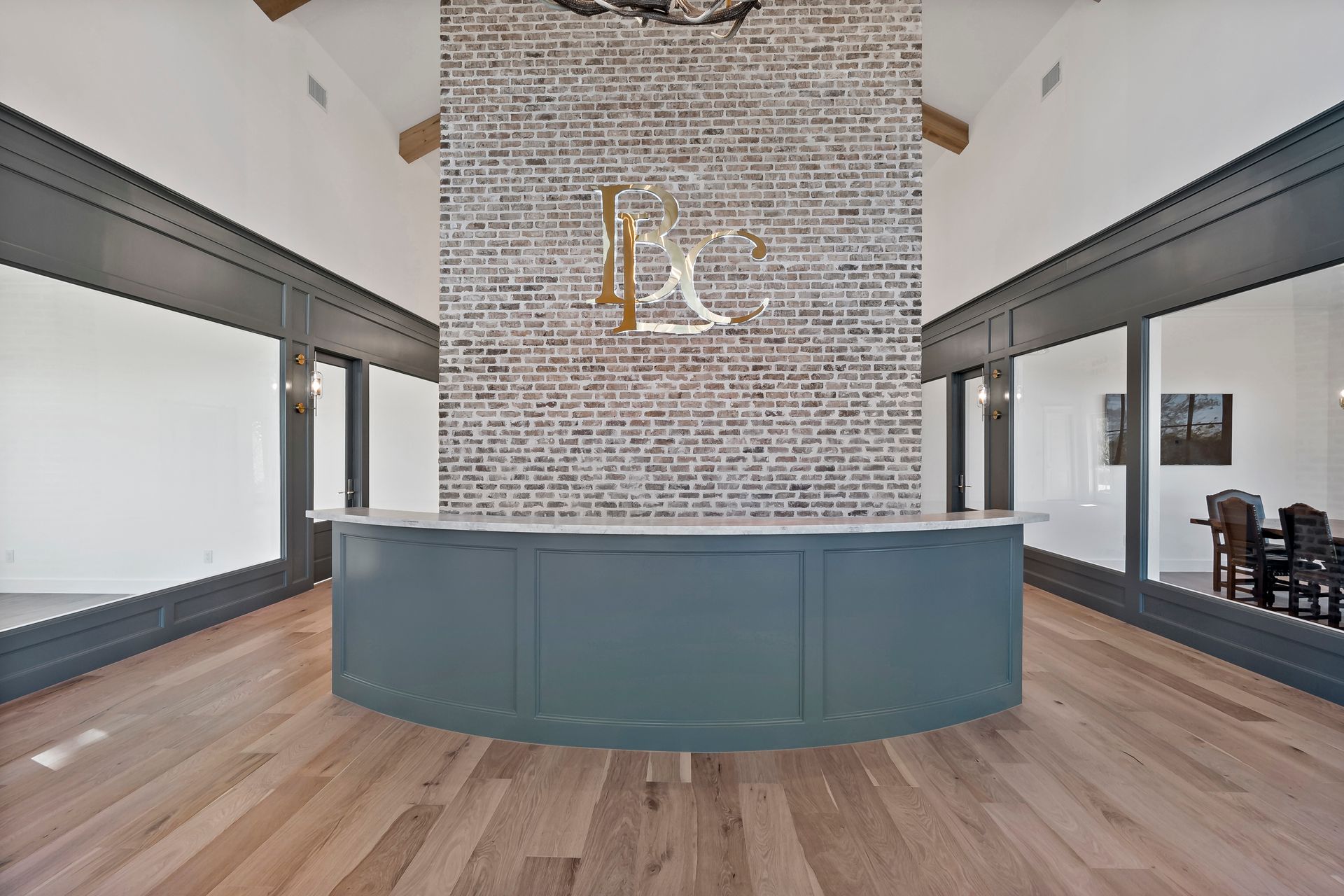 A large room with a brick wall and a blue counter in the middle.