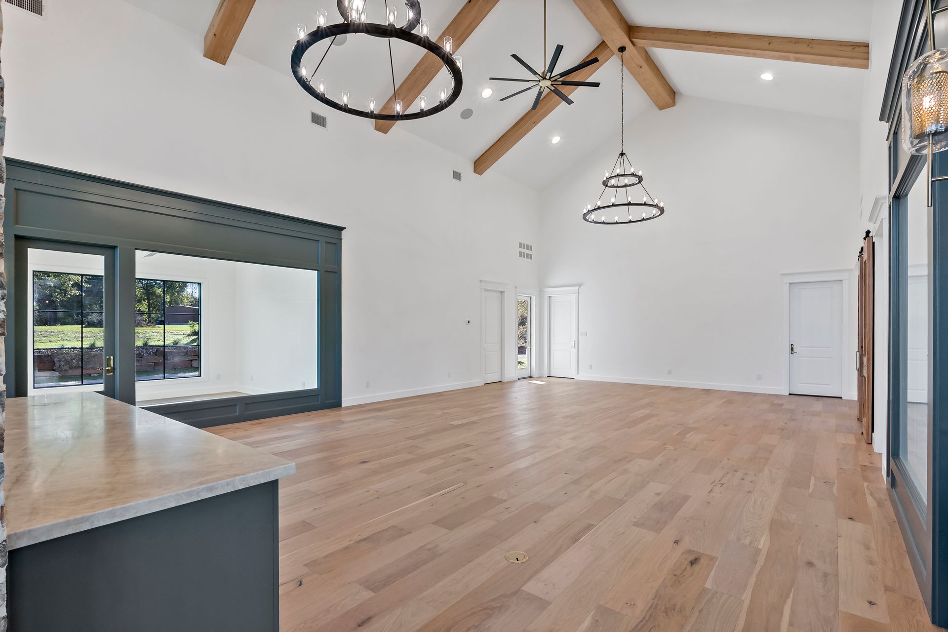 A large empty room with hardwood floors and a ceiling fan.