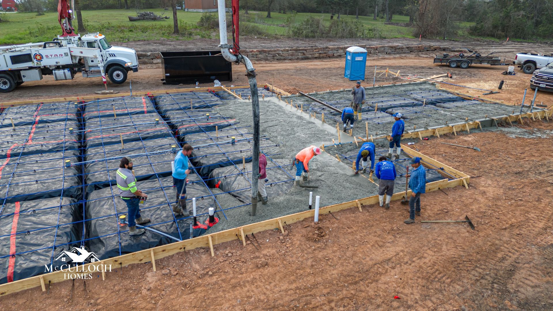 A group of construction workers are working on a concrete floor.