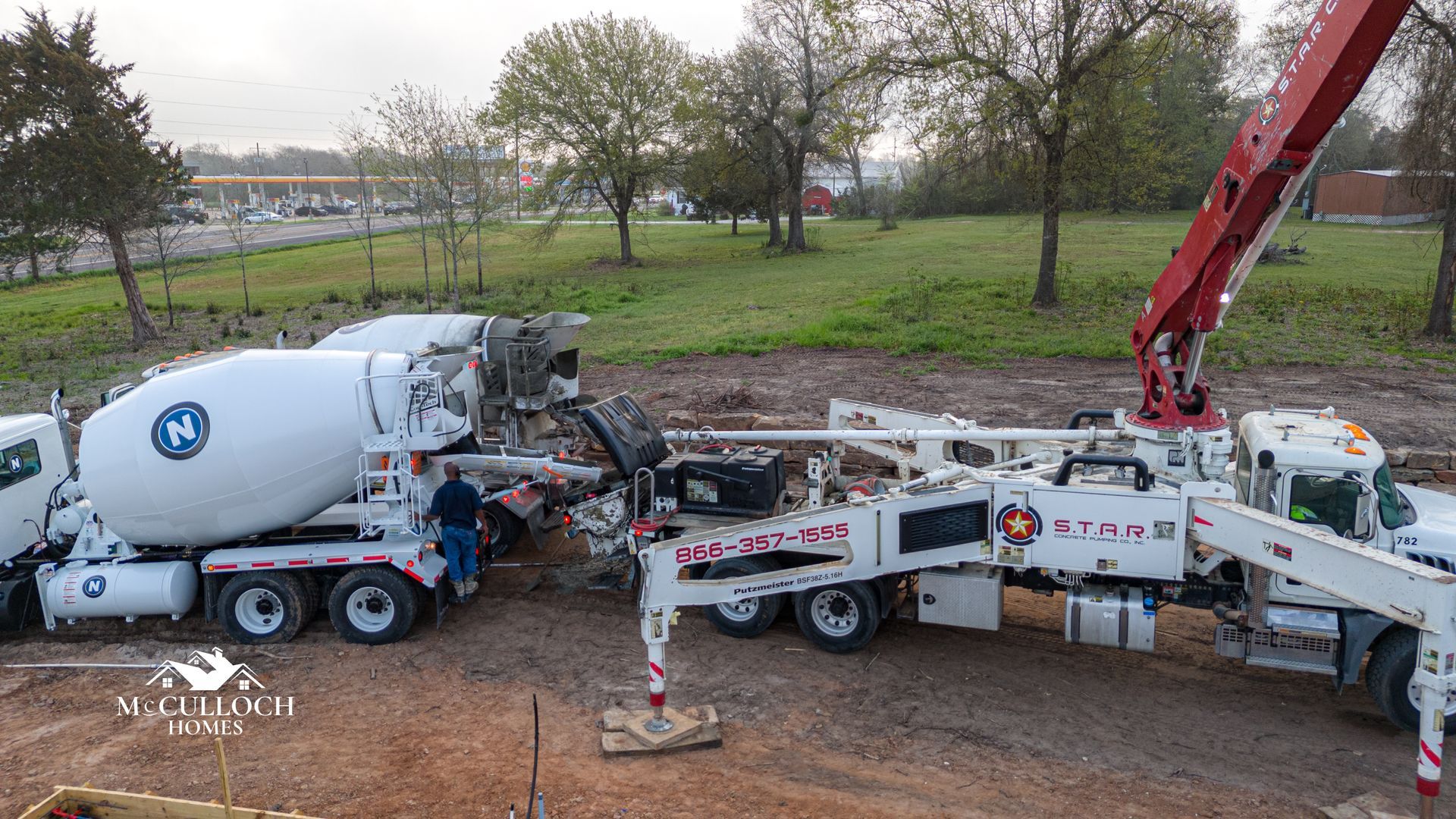 A concrete mixer truck and a concrete pump truck are working on a construction site.