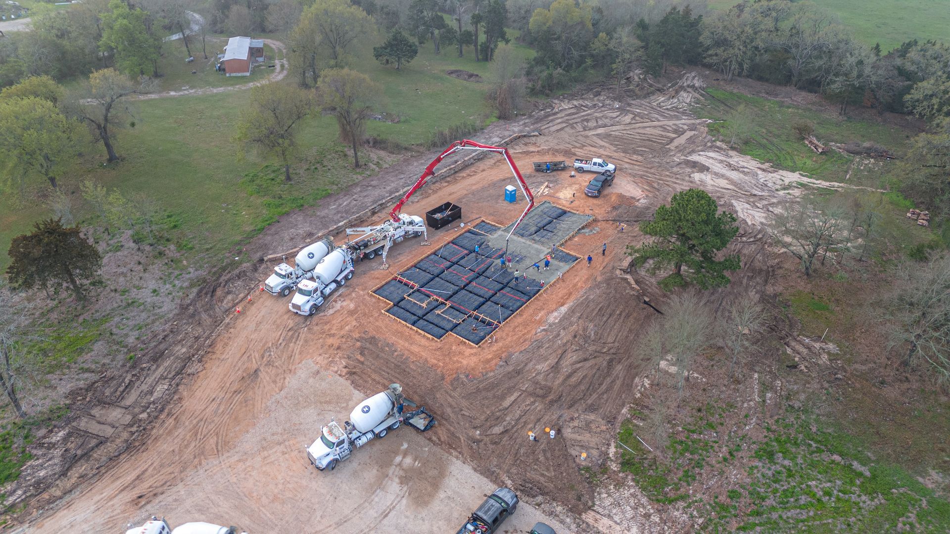 An aerial view of a construction site with trucks and a crane.