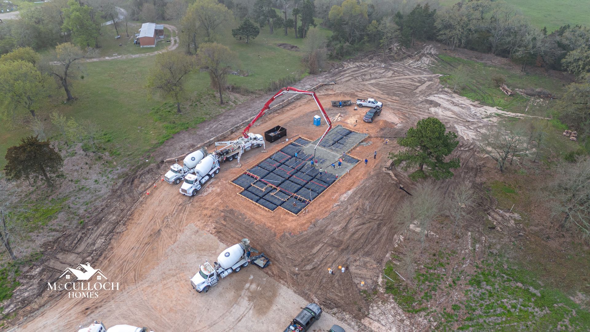 An aerial view of a construction site with trucks and a crane.