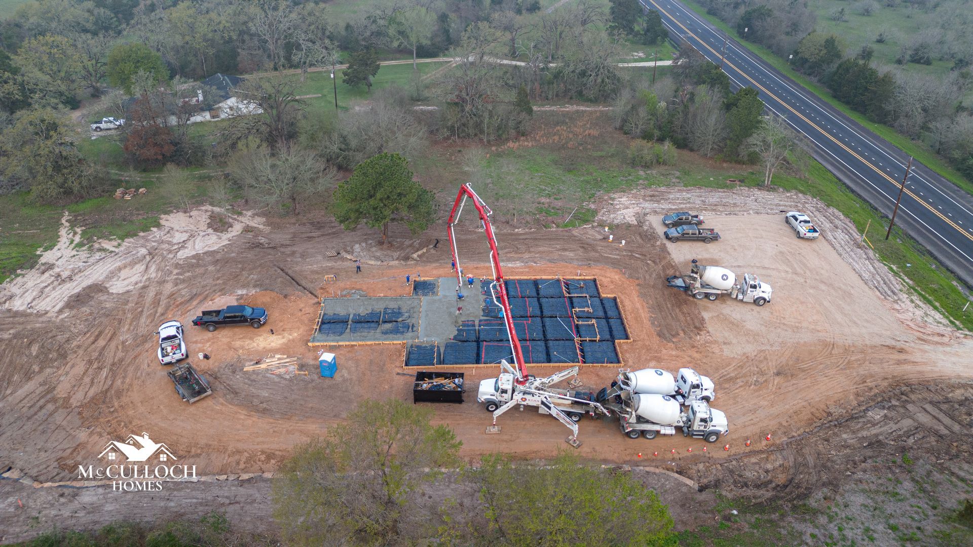 An aerial view of a construction site next to a highway.