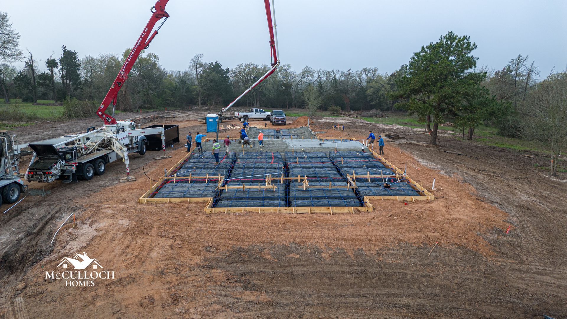 An aerial view of a construction site with a concrete pump.