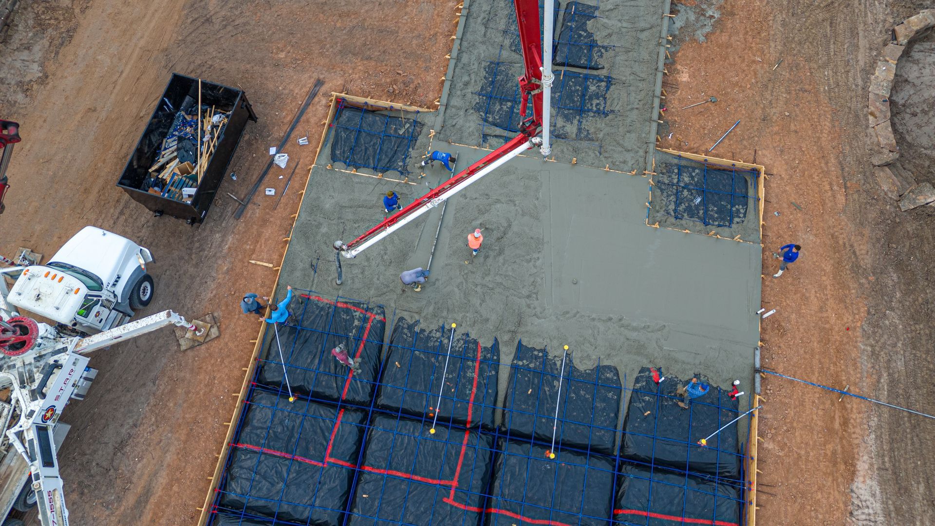 An aerial view of a construction site with a truck pouring concrete.