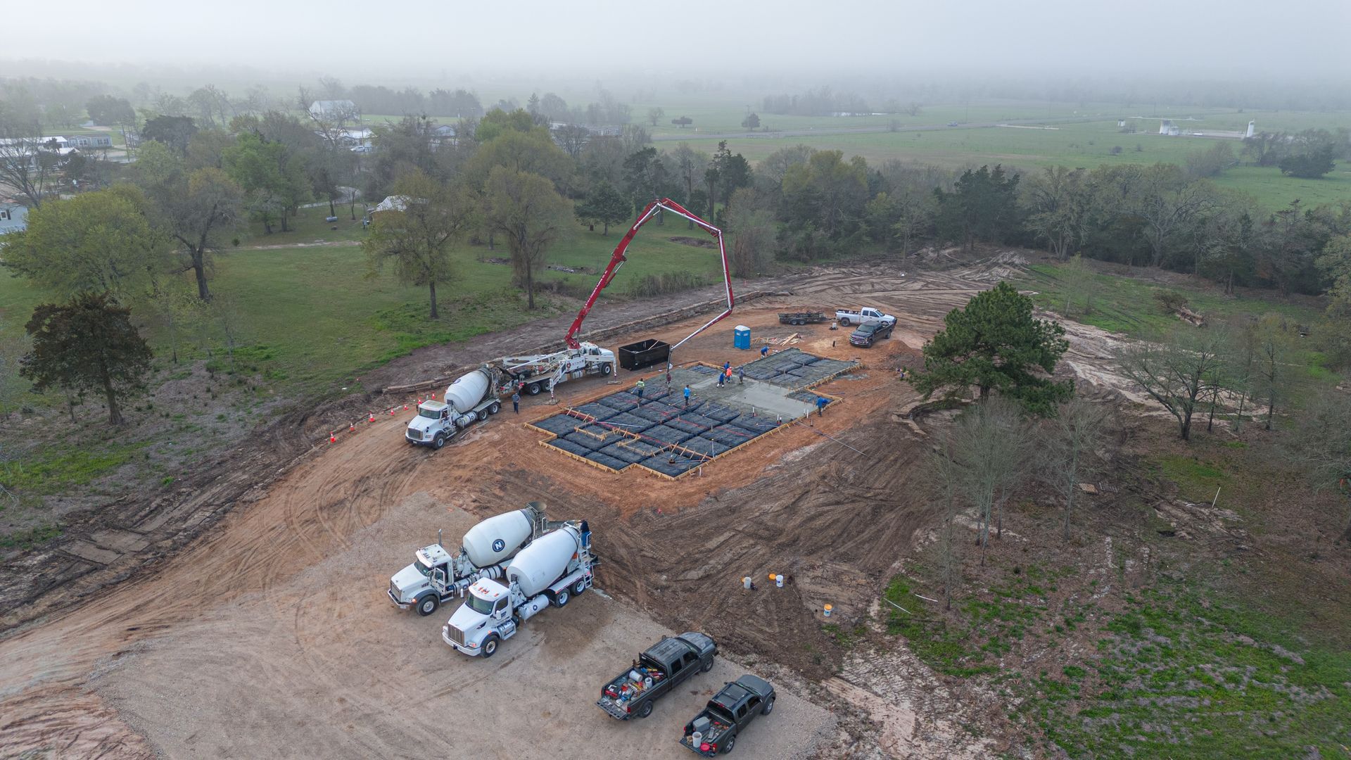 An aerial view of a construction site with trucks and a crane.