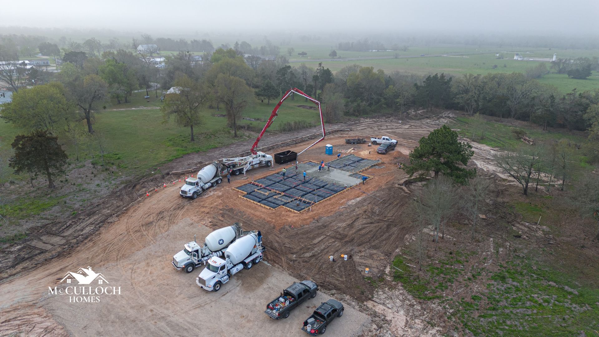 An aerial view of a construction site with trucks and a crane.