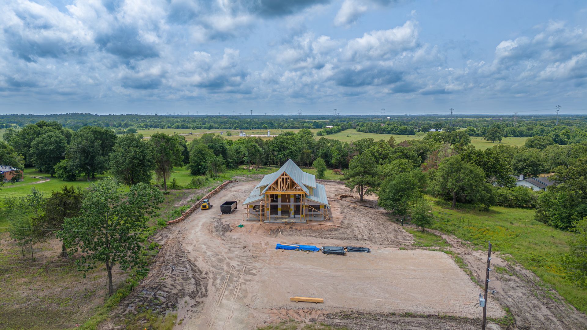 An aerial view of a house under construction in the middle of a field.