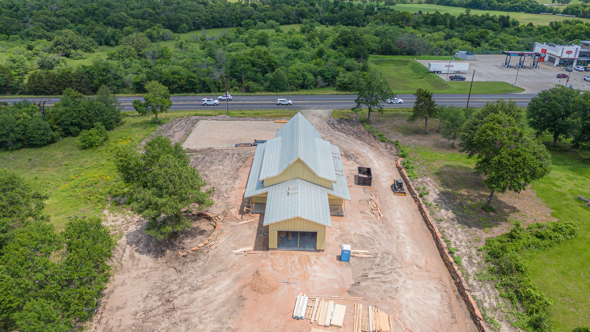 An aerial view of a building under construction in the middle of a field.