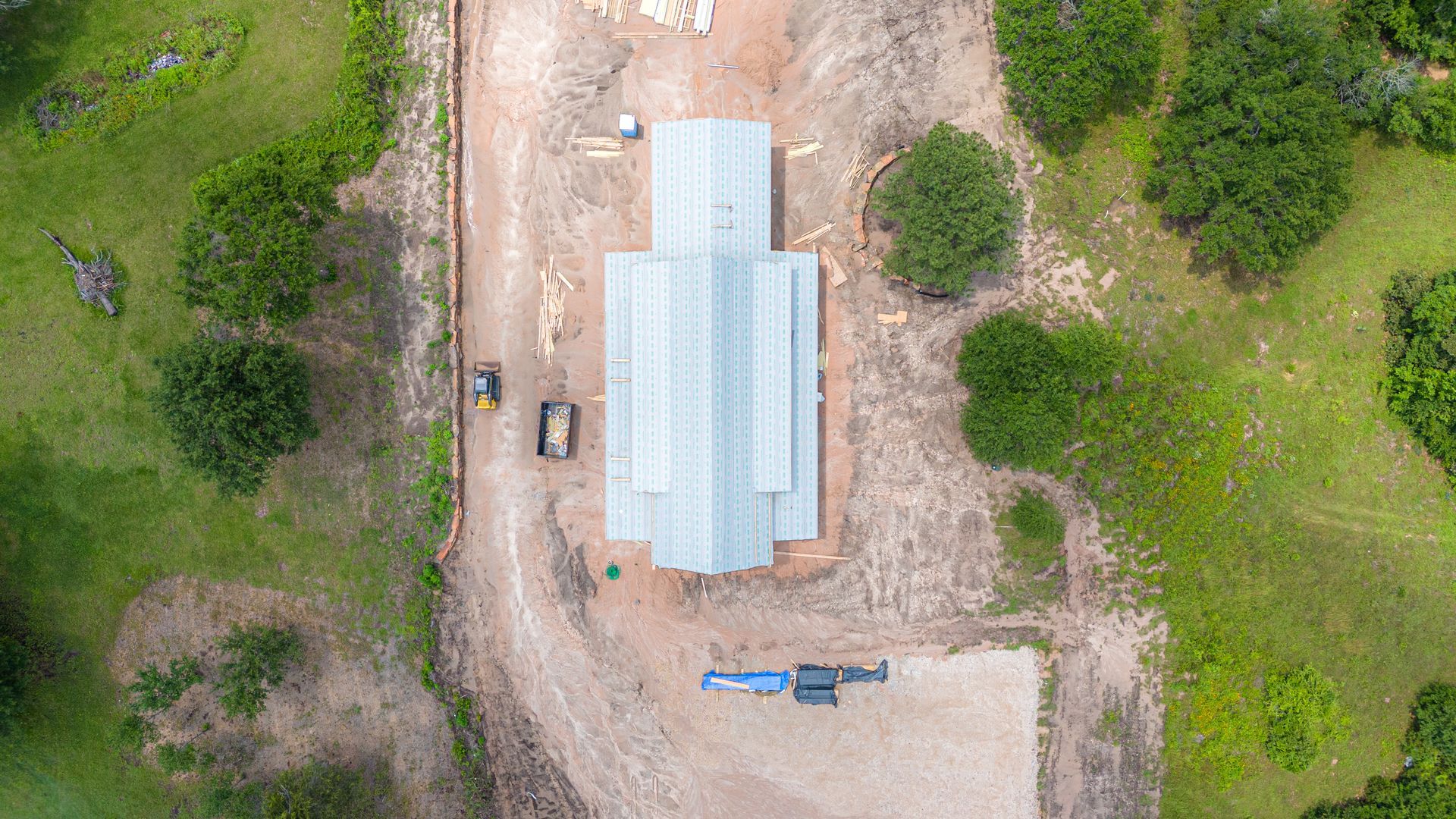 An aerial view of a building under construction in the middle of a field.