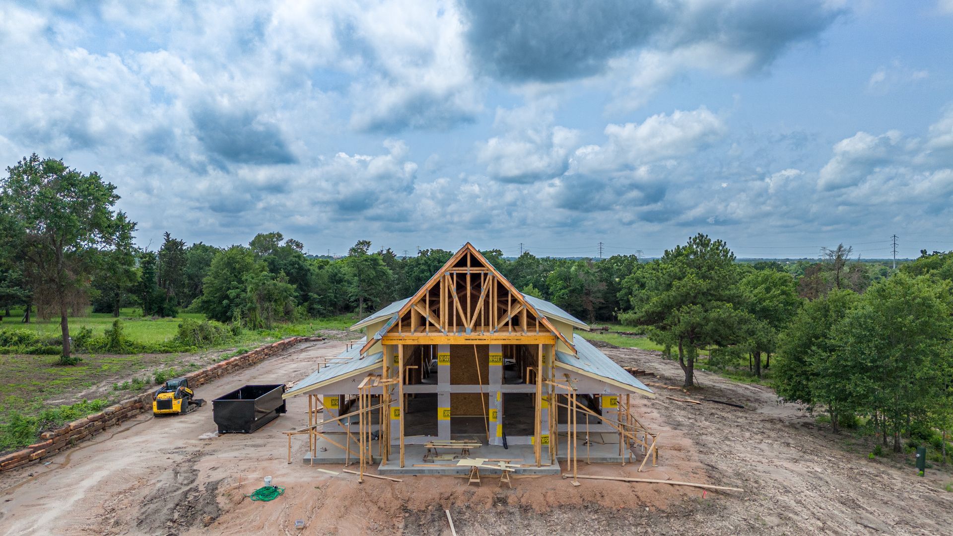 An aerial view of a house under construction in the middle of a dirt field.